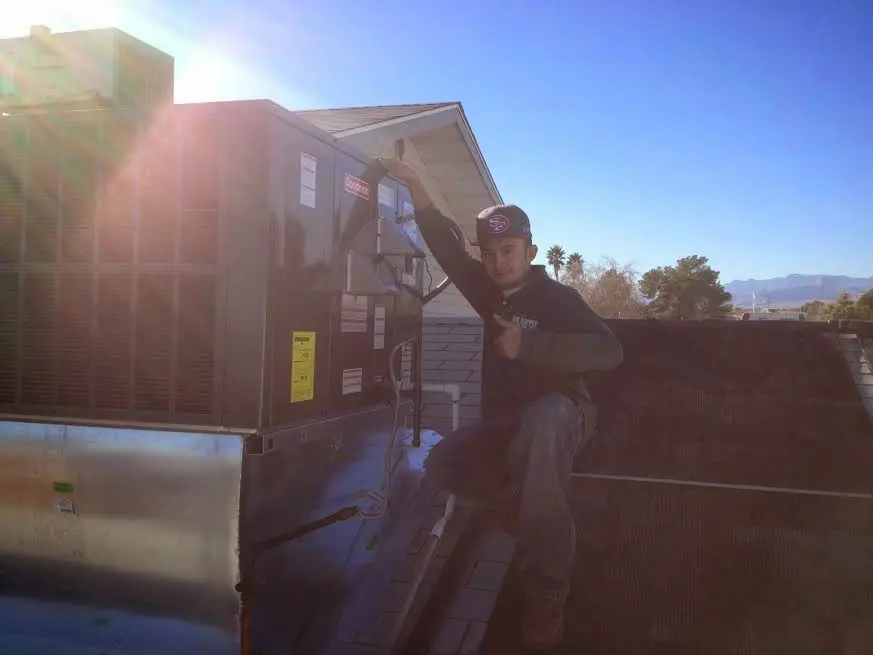 HVAC technician performing AC Tune-Up on a rooftop unit in River Oaks